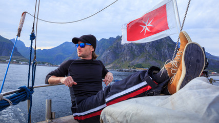 Sailor man resting in boat in open sea in Norway