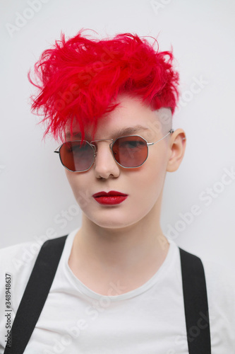 Portrait Of A Cool Fashionable Modern Young Girl A Short Haircut With Shaved Temple Dyed Bright Red Hair Red Lipstick Studio Photo On White Background Suspenders And Checkered Pants Wall Mural Spaskov Portrait Of A Cool Fashionable Modern Young Girl A Short Haircut With Shaved Temple Dyed Bright Red Hair Red Lipstick Studio Photo On White Background Suspenders And Checkered Pants Wall Mural Spaskov