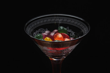 a martini glass filled with candy. Photo on a black background