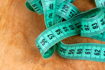 Measuring tape on the wooden background