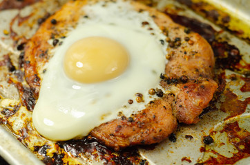 Fried portion of gammon served with egg on the metal plate