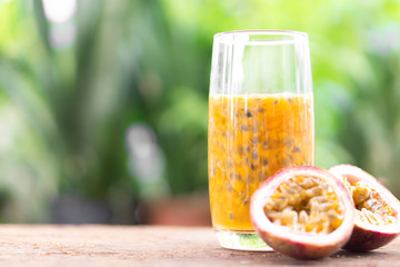 Glass of passion fruit juice wood table with green nature background, food healthy concept, selective focus