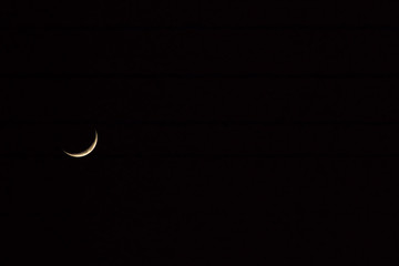 Rome, Between the buildings of the city, between the balconies, a bright wedge of the moon appears.