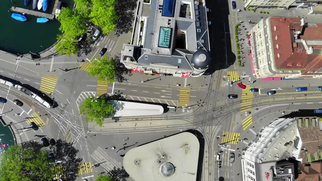 Aerial Drone Shot of Swiss Crossroad and Bellevue Tram Station Located in Z&uuml;rich - Turning Top View while Traffic is Moving