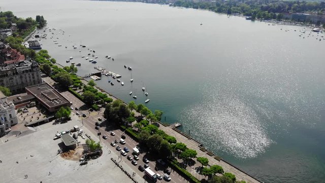 Beautiful Drone Aerial Flying over Big Square Sechsel&auml;utenplatz, Lake and Revealing Bridge and River with Lots of People Moving - Turning Shot