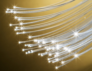 Bundle of optical fibers with lights in the ends. Yellow background.