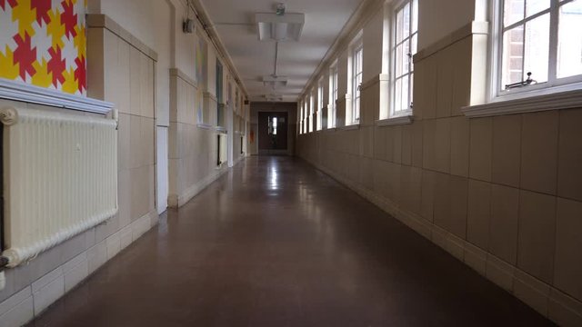 4K: Empty School or College Corridor with no people. The Long hallway is deserted in this place of eductation. Low Tracking Shot. Stock Video Clip Footage