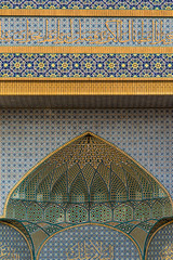 Fototapeta na wymiar Abstract fragment of a mosque facade with decor of colorful mosaic and ornamental tiles in Qom, Iran