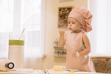 Little girl cooks at home in the kitchen