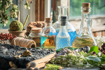 Ancient magic recipe book and magic potions in the bottle on the witch doctor table background.