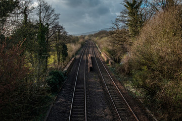 An empty railway track in the UK, under a cloudy spring sky