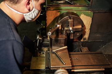 Professional machinist : man operating lathe grinding machine