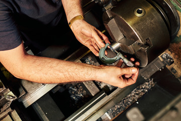 Professional machinist : man operating lathe grinding machine