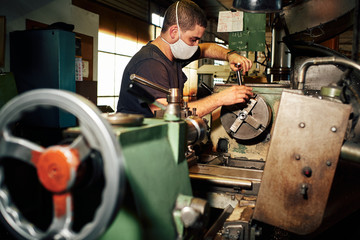 Professional machinist : man operating lathe grinding machine