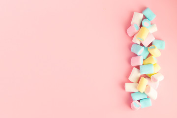 multicolored colored vibrant marshmallows on a pink background. the concept of childhood.