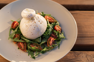 Burrata salad with cherry kumato tomatoes with black pepper.