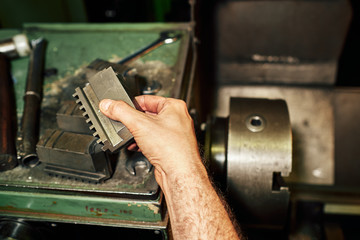 Obraz na płótnie Canvas Professional machinist : man operating lathe grinding machine