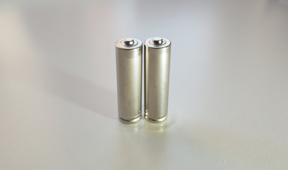 Two aa gray batteries on a white background