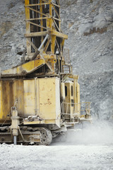 Working part of the equipment of a mining drilling machine in a cloud of dust, closeup. Heavy mining equipment.