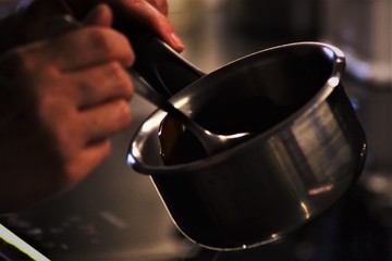 Fototapeta na wymiar Stirring hot chocolate on a cooking pot.