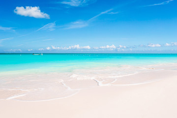 Idyllic tropical beach in Caribbean with white sand, turquoise ocean water and blue sky