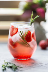 Soda cocktail with strawberry and ice at light background
