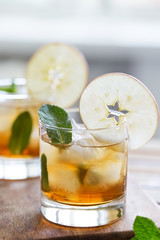 Apple juice with mint and ice, slice of apple at glass.