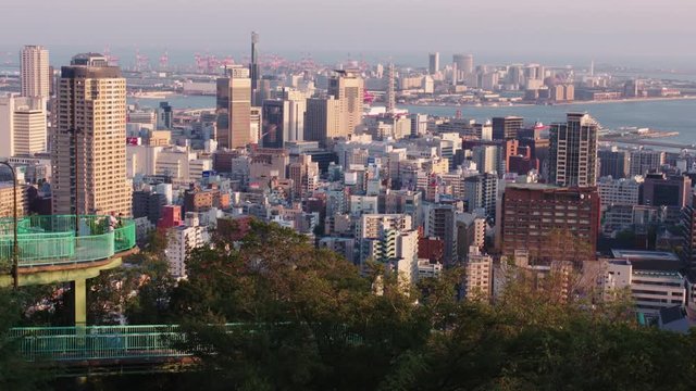 Skyline of Kobe in Japan on a sunny day, dense cityscape with harbour in distance