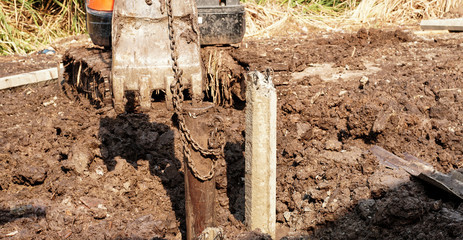 Fototapeta premium Piles are made of cement and hammered into the ground using a backhoe.