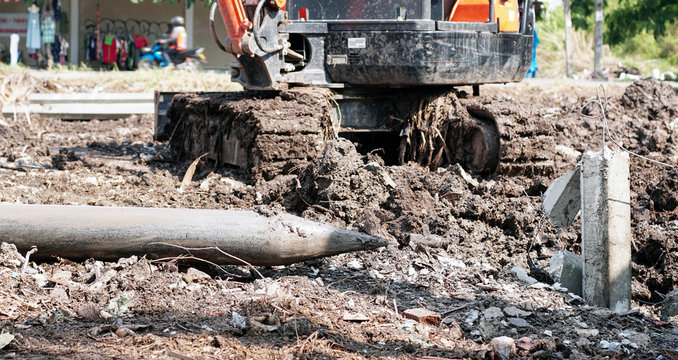 Piles are made of cement and hammered into the ground using a backhoe.