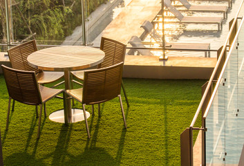 Empty Wooden Tea table on rooftop garden by swimming pool in the evening
