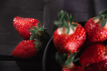 Fresh ripe strawberries on a black wooden background