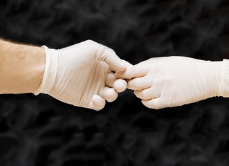 people in medical gloves holding hands