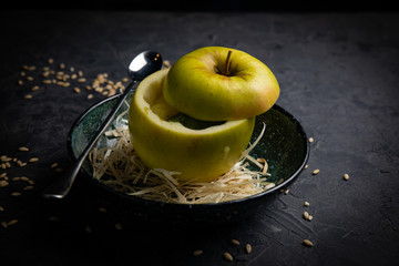 
Apple ice cream in a green apple. On a plate on a dark background