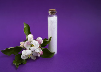 Beautiful white blossoms. Defocused salt for shower in the glass jar. Copy space. Place for text and design.