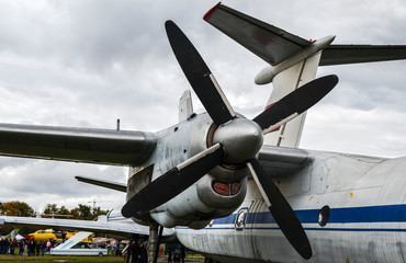 Engine, propeller and wing of an old vintage airplane against cloudy sky