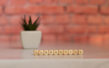 the word quarantine is written on a wooden block. Quarantine text on a wooden table for your design, concept view of a coronavirus.