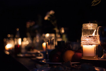 Fototapeta na wymiar candle glass dark light table holiday night