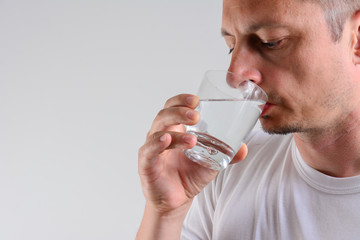 Handsome Man Drinking Glass Of Fresh Water isolated on white background.