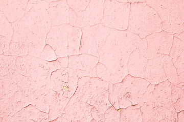 Old pink dirty wall with cracked and peeling paint surface texture background.
