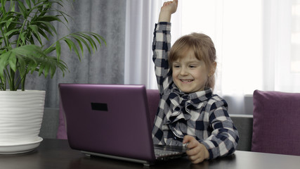 Girl learning online lessons using digital laptop computer. Distance education