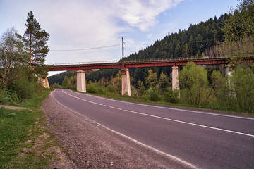 Naklejka premium railway bridge across the road in the mountains is a beautiful building