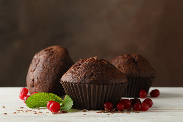 Composition with chocolate muffins and berries on white wooden table