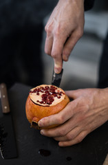 
man cut a pomegranate