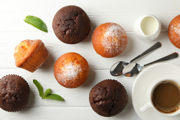 Composition with muffins and cocoa drink on white wooden background