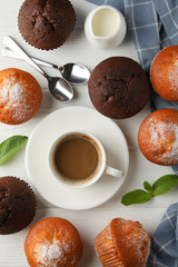 Composition with muffins and cocoa drink on white wooden background