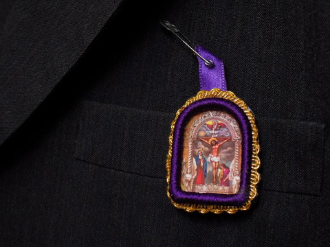 Imagen del Se&ntilde;or de los Milagros colgada sobre solapa de traje