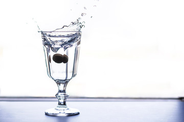 The tablet falls into a glass with water and sprinkles drops