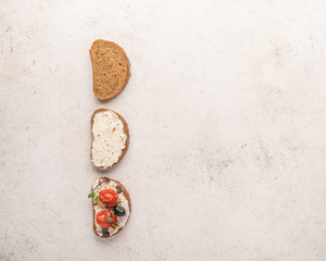 Stages of making a sandwich of bread, ricotta cheese, salted salmon, baked tomatoes and greens on light background