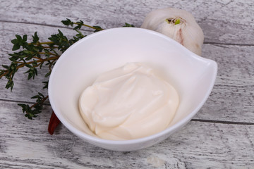 Mayonnaise sauce in the white bowl served thyme and garlic